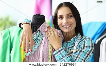 Portrait Of Cheerful Garment Factory Tailor Posing Near Mannequin. Exemplars With New Clothes. Tape 
