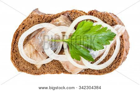 Top View Of Open Sandwich With Rye Bread And Pickled Herring Decorated Of Onion Rings And Fresh Gree