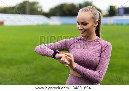 Sport And Technology. Beautiful Young Whiteskinned Woman With Ponytail At Running Stadium In Front O