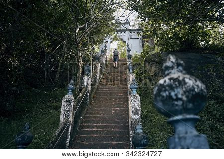 Young Tourist Climbs Up Stairs To Gate Of Ancient Temple Near Tangalle. Mulkirigala, Sri Lanka.