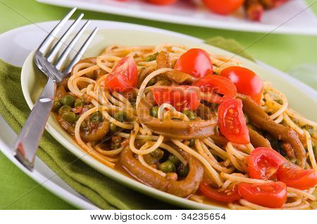 Spaghetti with squids peas and cherry tomatoes.