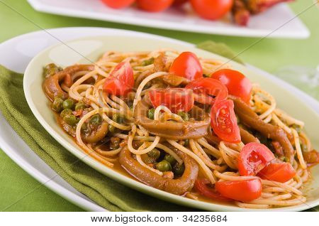 Spaghetti with squids peas and cherry tomatoes.