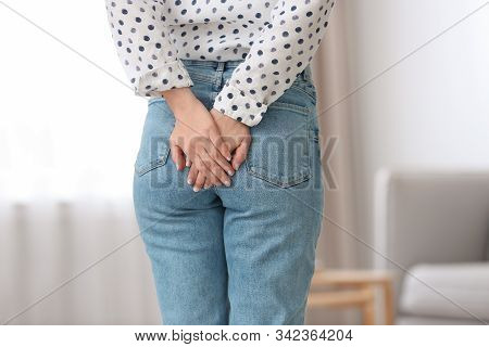 Young Woman Suffering From Hemorrhoid At Home, Closeup