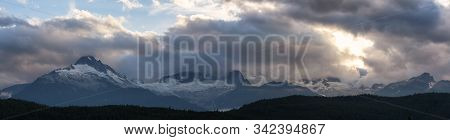Striking And Dramatic Panoramic Canadian Landscape View Of The Mountain Peaks During A Cloudy Sunset
