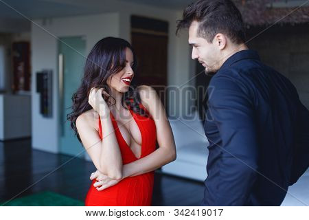 Sexy Woman In Red Seducing Younger Man Indoors