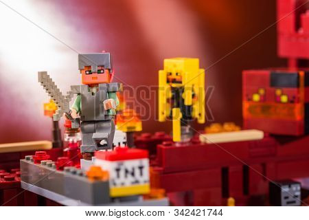 Kiev, Ukraine - December 29, 2019: Minifigure Alex With Sword Run Away From The Blaze And Magma Cube
