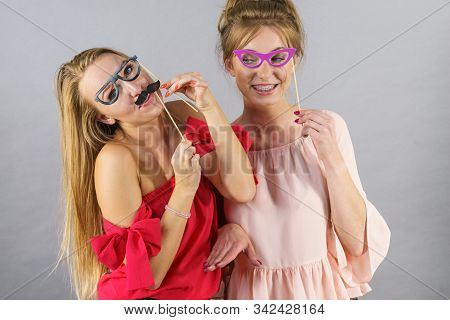 Happy Two Women Holding Paper Decoration Photo Booth Mask Glasses And Moustache On Stick, Having Fun