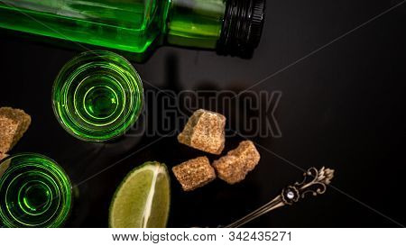 Absinthe Or Mint Liquor Shot. Absinthe In Glass With Lime Slices On Dark Background. Alcohol, Luxuri