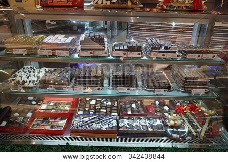 Close Up Of Several Chocolate Sweets In A Shop. Chocolate Candy In A Store Window. Stand With Chocol