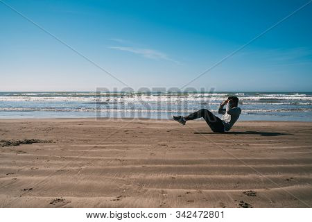 Athletic Man Doing Exercise At The Beach.