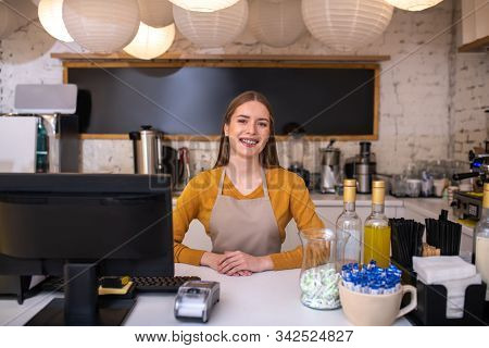Smiling And Cheerful Cafe Employee Waiting For Clients