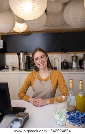 Charming And Smiling Barista Standing At The Counter