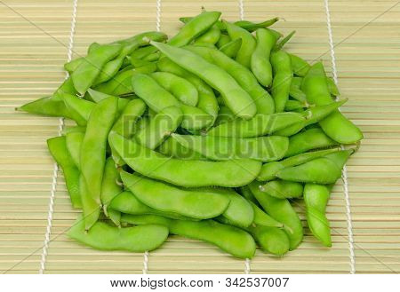 Pile Of Boiled Edamame, Green Soybeans, Maodou, On A Bamboo Mat. In Saltwater Cooked Soy Beans, Glyc