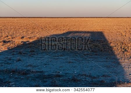 A Safari Truck Casting A Long Shadow Around Sunset In Etosha National Park, Namibia