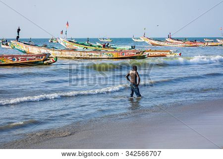 Tanji, The Gambia - November 21, 2019: Scene With Men And Women Carrying Fish From The Boats To The