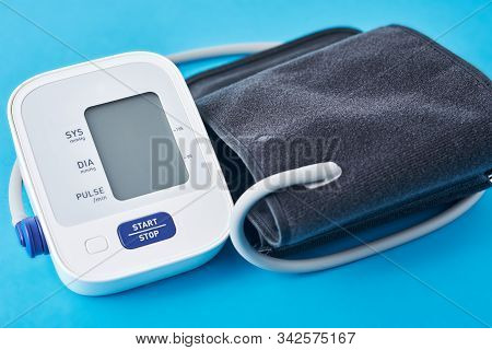 Digital Blood Pressure Monitor On A Blue Background, Closeup. Helathcare And Medical Concept