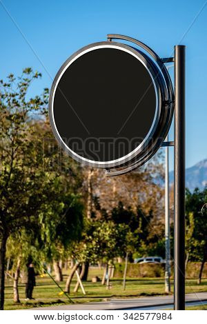 Round Black Signboard On The Street In The City