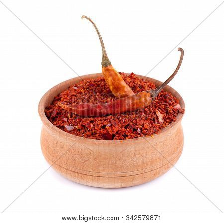 Dry And Crushed Chili Pepper Flakes Isolated On White Background. Red Chili Pepper In The Wooden Bow