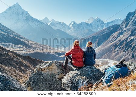 Couple Resting On The Everest Base Camp Trekking Route Near Dughla 4620m. Backpackers Left Backpacks