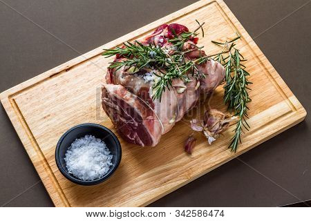 Raw Rolled And Tied Herdwick Sheep Lamb Joint Prepared With Garlic, Rosemary And Sea Salt.