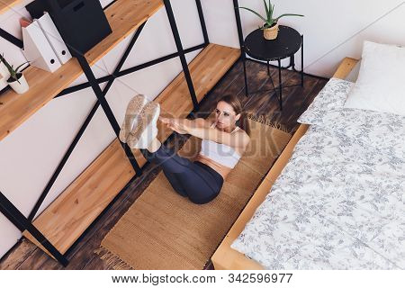 Attrctive Fitness Woman Doing Stretching Exercises At Home, As Part Of A Healthy Lifestyle Without G