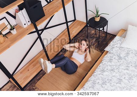 Attrctive Fitness Woman Doing Stretching Exercises At Home, As Part Of A Healthy Lifestyle Without G