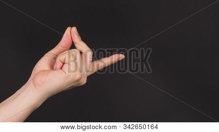 Male Model Is Doing Snap Gesture With Left Hand Sign On Black Background.