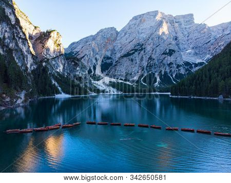 Braies Lake in Dolomites mountains forest trail in background, Sudtirol, Italy. Lake Braies is also known as Lago di Braies. The lake is surrounded by forest which are famous for scenic hiking trails.