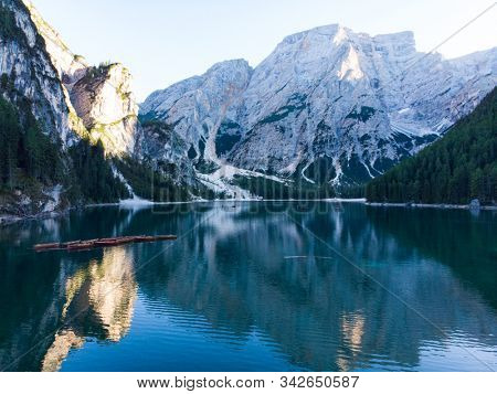 Braies Lake in Dolomites mountains forest trail in background, Sudtirol, Italy. Lake Braies is also known as Lago di Braies. The lake is surrounded by forest which are famous for scenic hiking trails.