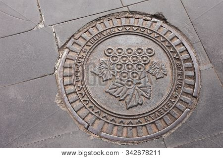 Erevan, Armenia-april, 28 2019: Sewer Hatch With Bunch Of Grapes Image On Erevan Street. Armenia