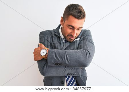 Young handsome business man wearing suit and tie over isolated background Hugging oneself happy and positive, smiling confident. Self love and self care