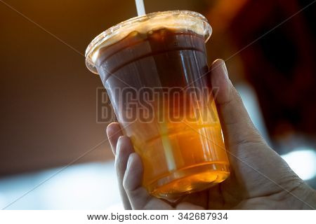 Glass Of Espresso Shot Mixed With Soda Or Sparkling Water In Hand