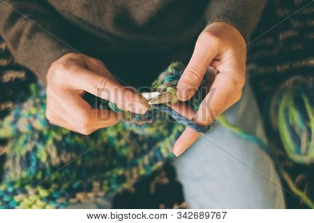 A Woman Knits From Thick Yarn. Handmade Clothes. The Girl Sits On The Couch And Goes In For Her Hobb