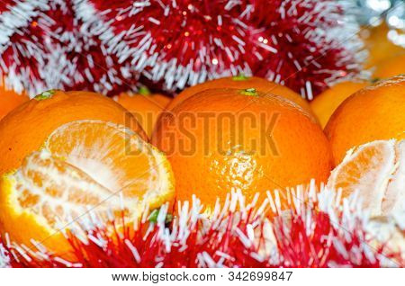 Bright Juicy Tangerines In Christmas Shiny Tinsel, The Concept Of Winter Holidays And A Large Harves