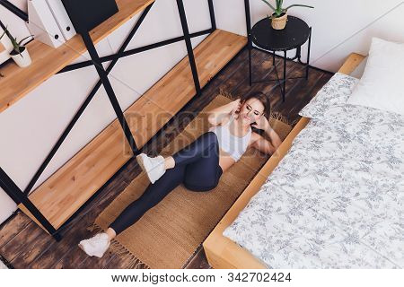 Attrctive Fitness Woman Doing Stretching Exercises At Home, As Part Of A Healthy Lifestyle Without G