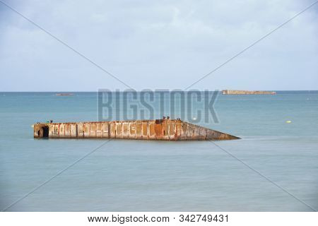 Ruins of harbor built by the Allies in Arromanches, Normandy, France.