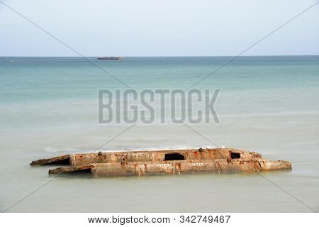 Ruins of harbor built by the Allies in Arromanches, Normandy, France.