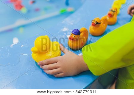 Fishing In The Paddling Pool. Childrens Toys In The Pool. Toy Fish Fishing Rod. Cheerful Children Fi