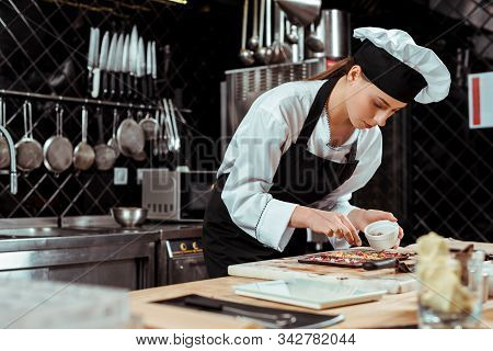 Selective Focus Of Attractive Chocolatier In Apron Looking At Dark Chocolate Bars