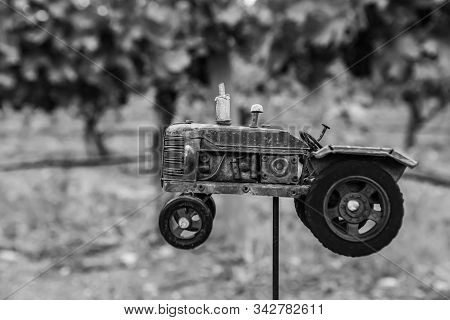 Handmade Red Tractor Metal Old Toy Selective Focus With Against Vineyard Vine Grapes Field Blurred B