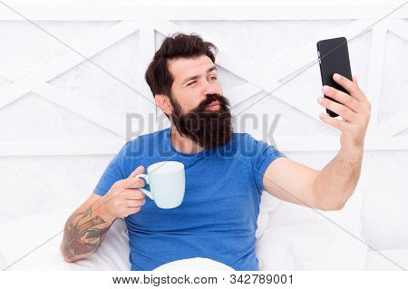 Selfie Kiss. Bearded Man Take Selfie In Bed. Hipster Smile To Selfie Camera In Mobile Phone. Enjoyin