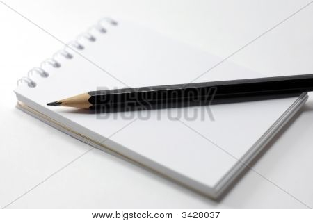 Notebook And A Black Pencil Close Up