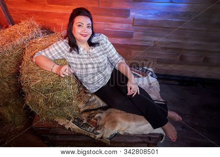 Portrait Of Fat Plump Fun Charming Cute Woman With Black Hair In The Room With Hay And Straw