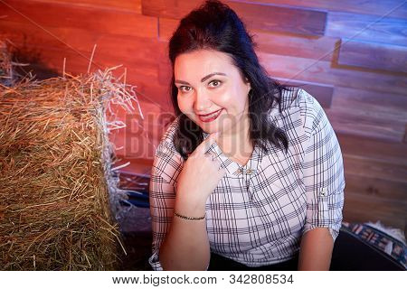 Portrait Of Fat Plump Fun Charming Cute Woman With Black Hair In The Room With Hay And Straw