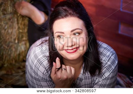 Portrait Of Fat Plump Fun Charming Cute Woman With Black Hair In The Room With Hay And Straw