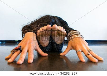 A Close Up And Front View On The Hands And Feet Of A Woman During A Mindful Yoga Posture, Paschimott
