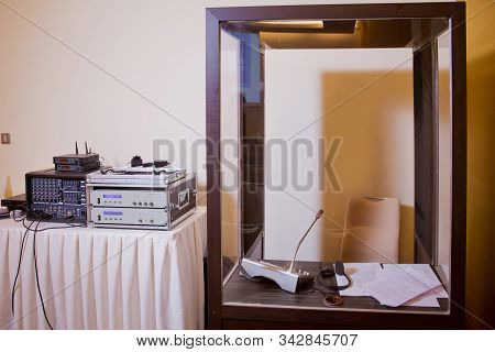Soft Focus Of Wireless Conference Microphones And Notebook In A Meeting Room. Translators Cubicle . 
