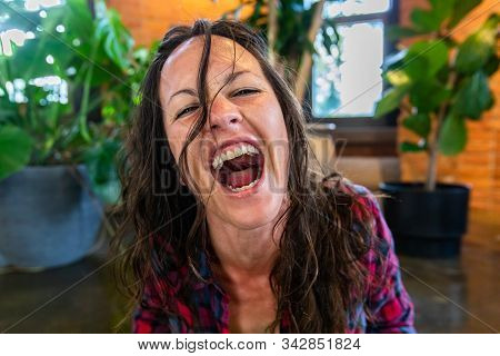 A Close Up And Front Portrait Of Crazy Mad Woman Screaming With Wide Open Mouth And Messy Brunette H