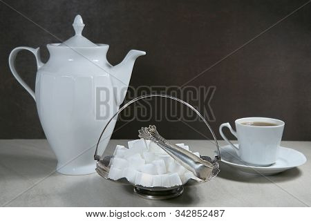 Sugar Cubes In Metal Vintage Sugar  Bowl With Sugar Tongs And Cups With Coffee Or Tea Pot.