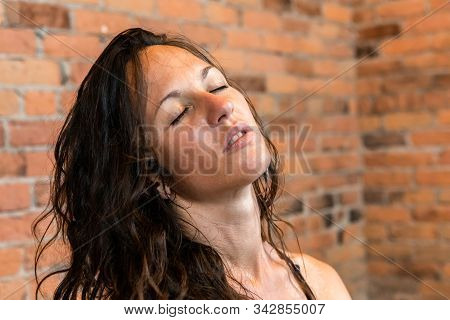 A Close Up Head Portrait Of A Beautiful Caucasian Woman With Closed Eyes And Sweaty Skin During An I